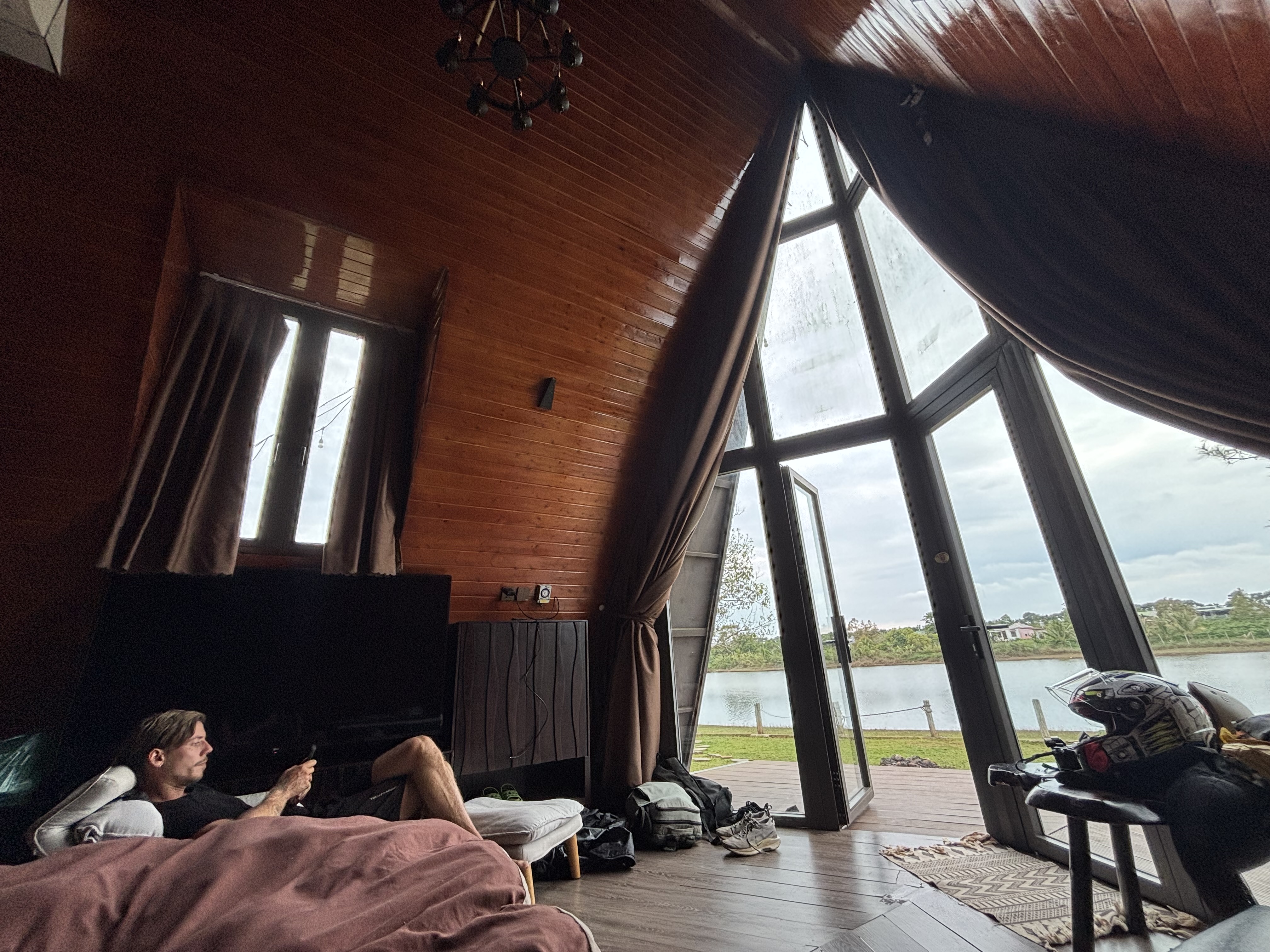 A-frame cabin with floor-to-ceiling windows overlooking a lake in the Central Highlands