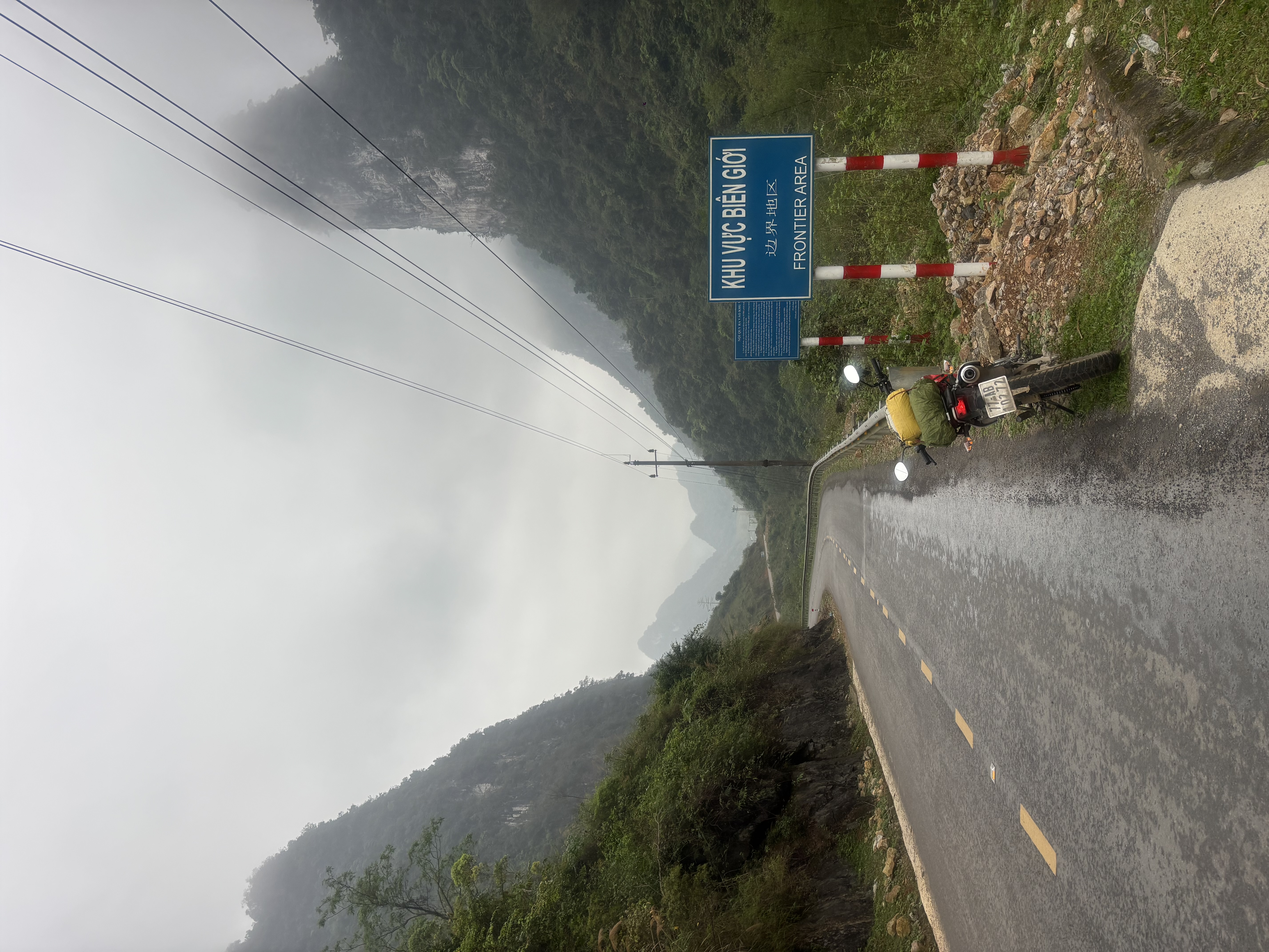 Motorbike at a Frontier Area sign on a mountain road along the Chinese border